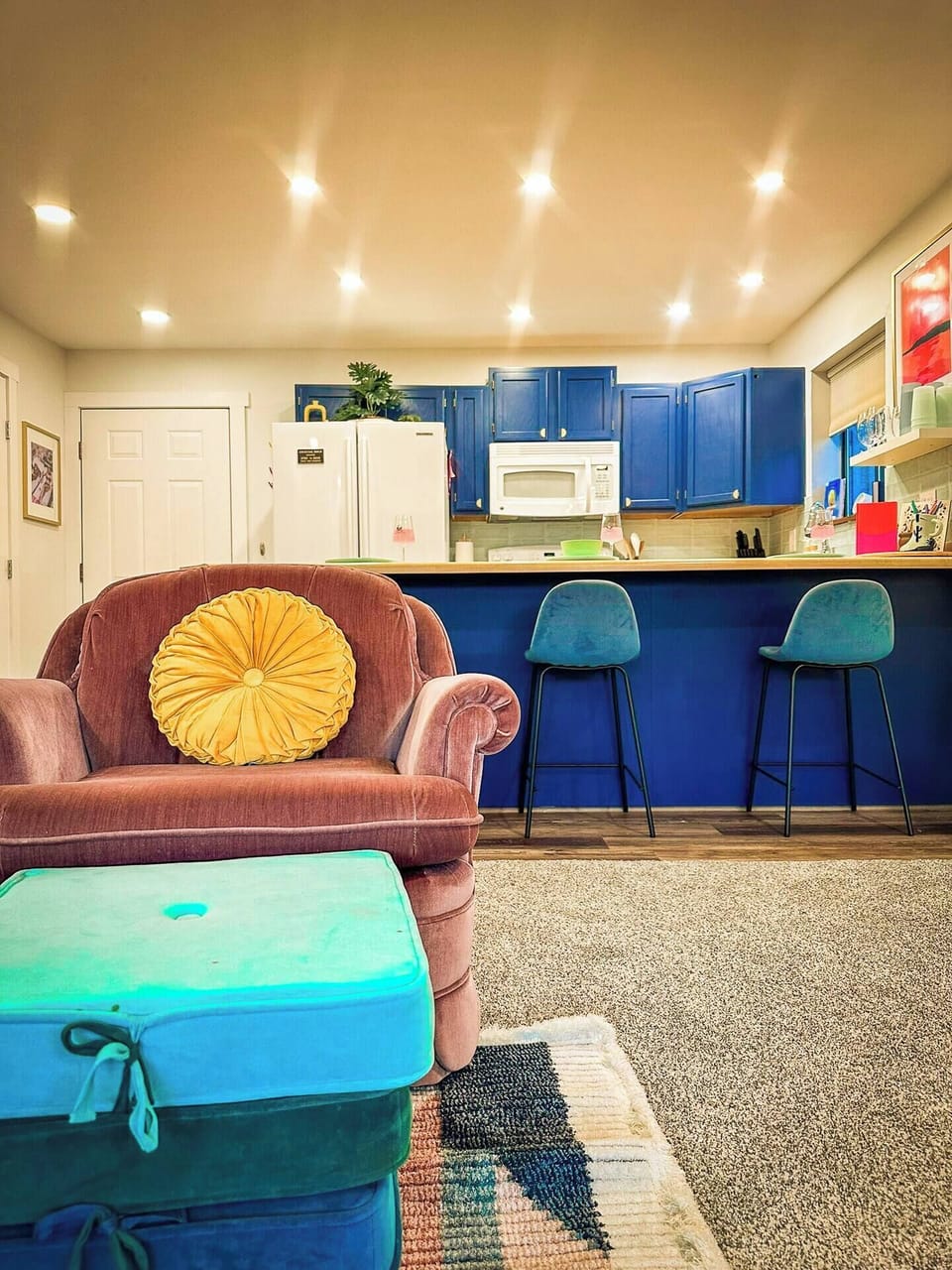 Relax in the inviting living room, complete with vibrant decor and a direct view of the fully equipped kitchen.