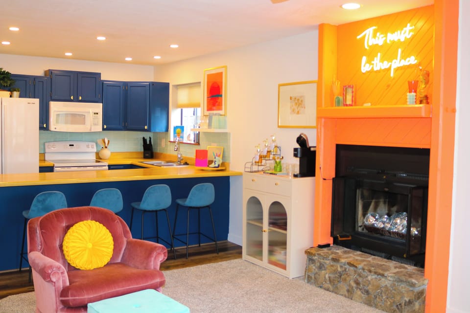 Relax and unwind in this vibrant living space, complete with a cozy fireplace and a cheerful vibe.