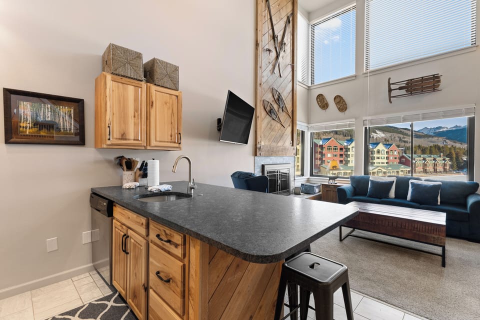 Full kitchen featuring updated stone countertops, stainless steel appliances, and breakfast bar.