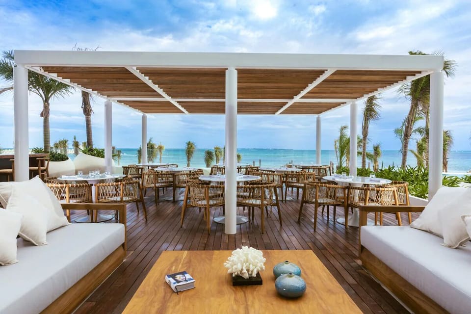 Sip cocktails under the canopy with panoramic ocean scenery.