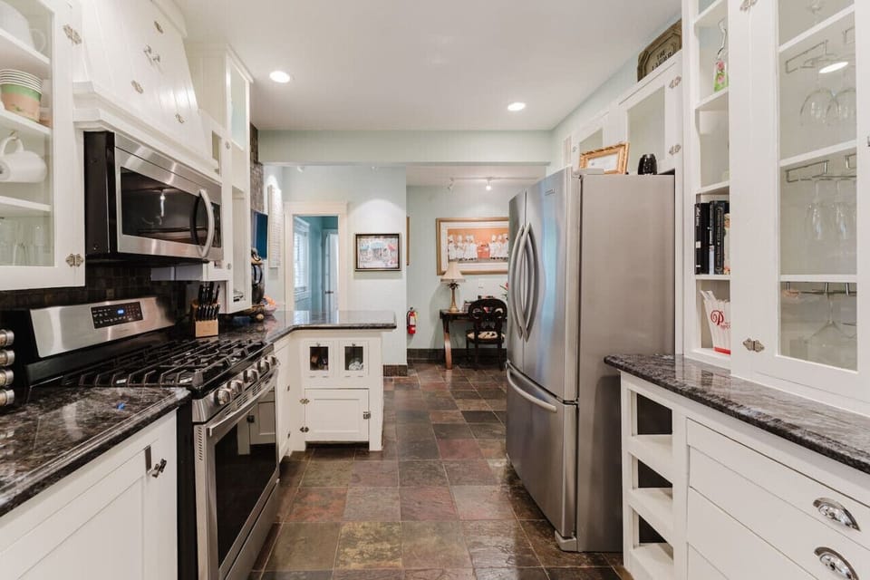 Another view of the spacious kitchen, complete with modern appliances, charming cabinetry, and a cozy workspace, making meal prep both stylish and convenient.