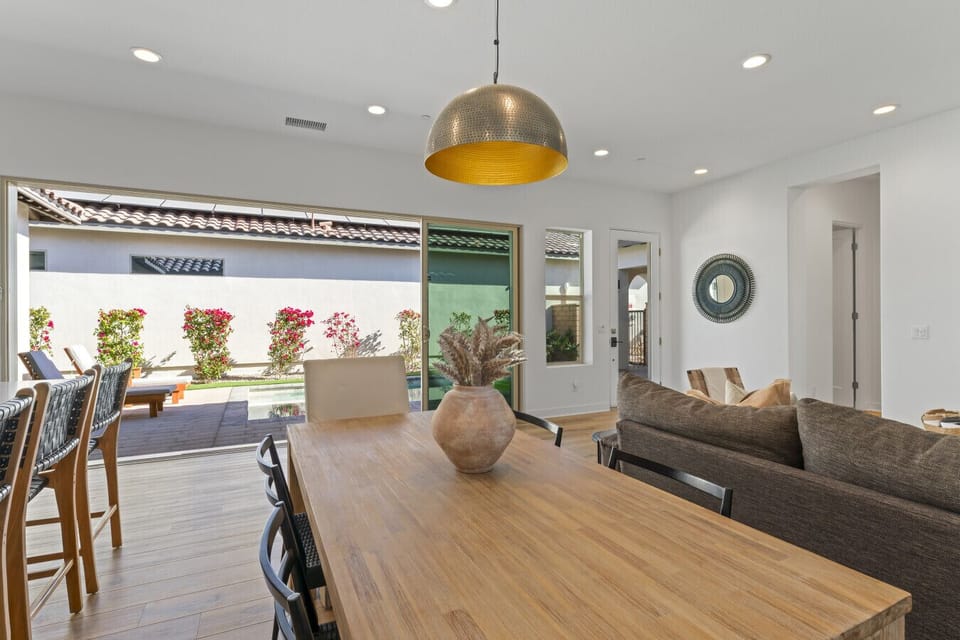Open living area w/ warm wood floors & sliding doors to the covered patio