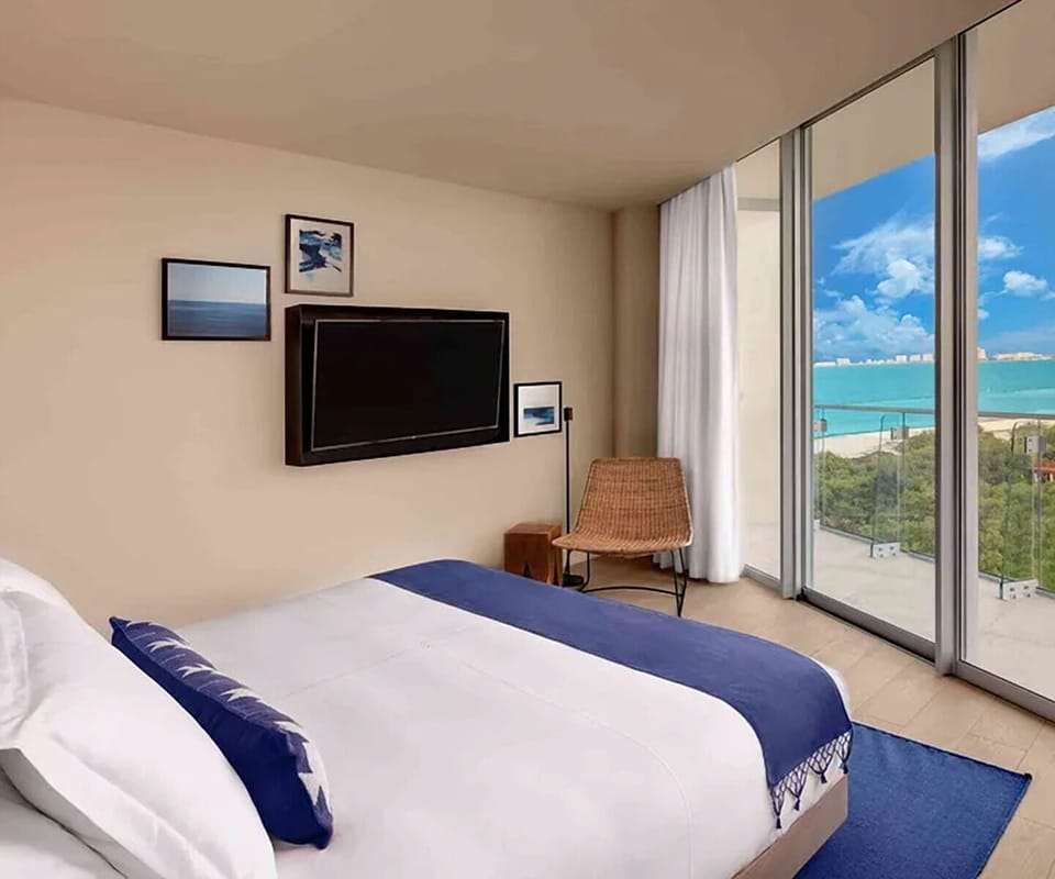 Unwind in crisp linens beside floor-to-ceiling sea views.