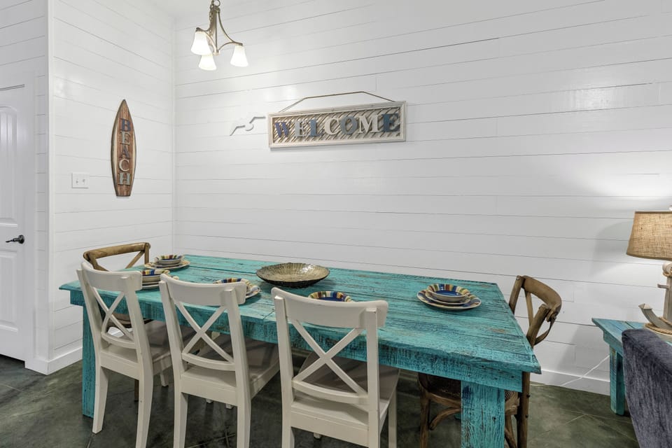 You'll love gathering around this charming turquoise farmhouse table, where coastal vibes meet comfort in your bright dining space.