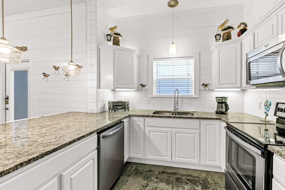 Your fully equipped kitchen features granite countertops, stainless appliances, and charming coastal decor to inspire culinary adventures.