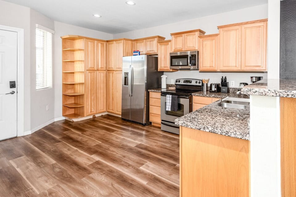 Modern functional kitchen with microwave, fridge, stove and basic cooking ware
