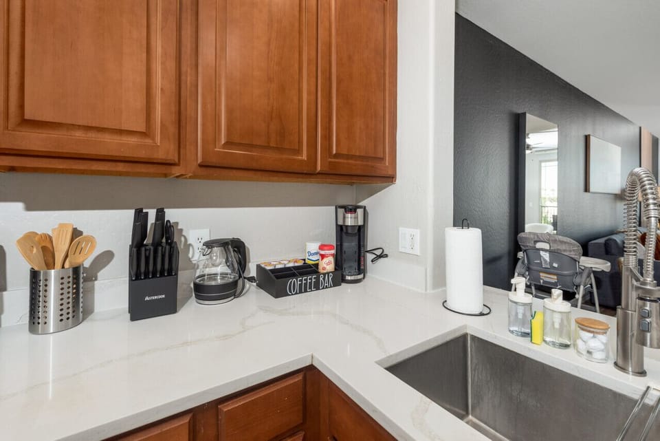Modern functional kitchen with microwave, fridge, stove and basic cooking ware