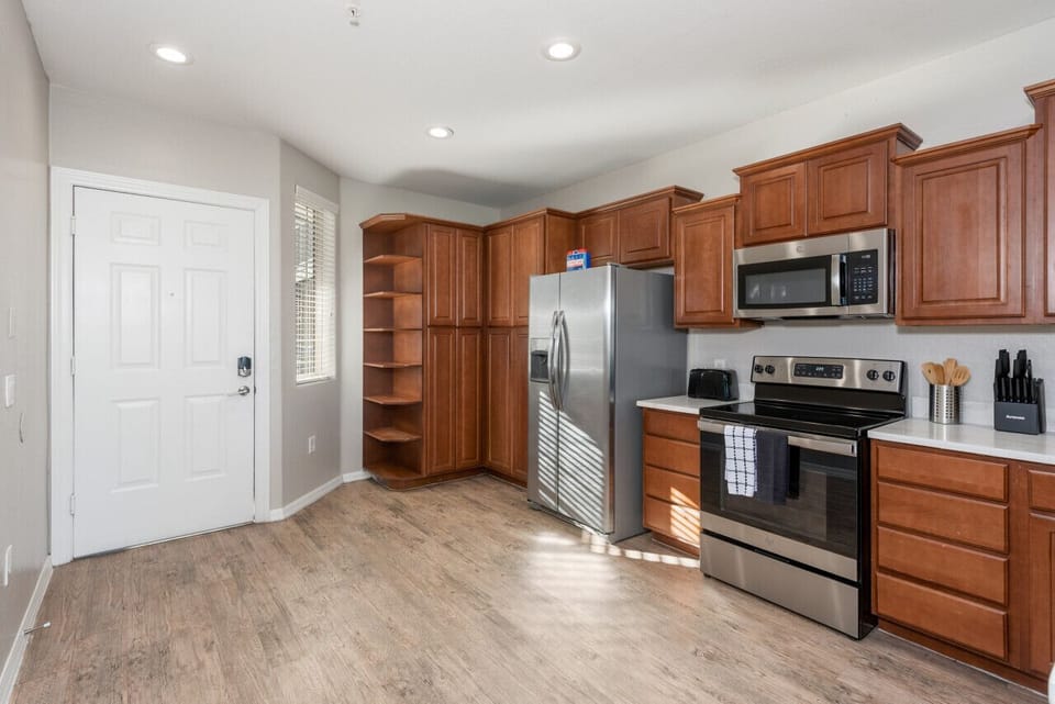 Modern functional kitchen with microwave, fridge, stove and basic cooking ware