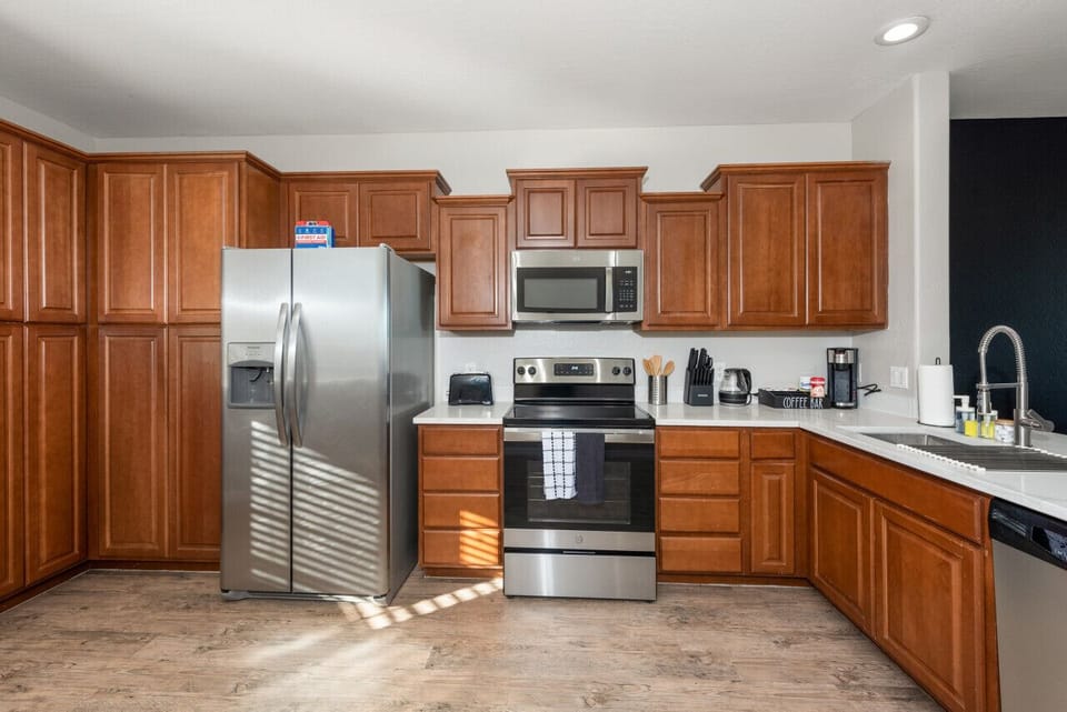 Modern functional kitchen with microwave, fridge, stove and basic cooking ware