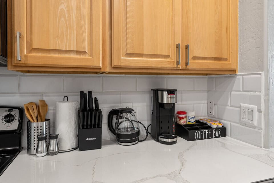Modern functional kitchen with microwave, fridge, stove and basic cooking ware