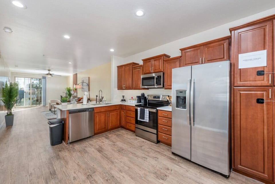 Modern functional kitchen with microwave, fridge, stove and basic cooking ware