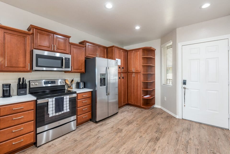 Modern functional kitchen with microwave, fridge, stove and basic cooking ware