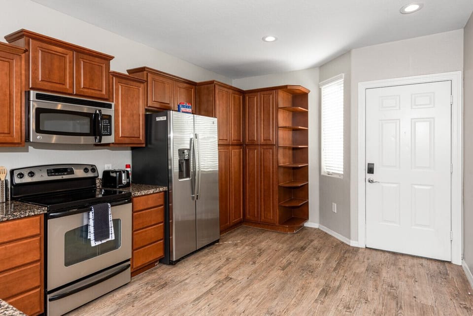 Modern functional kitchen with microwave, fridge, stove and basic cooking ware