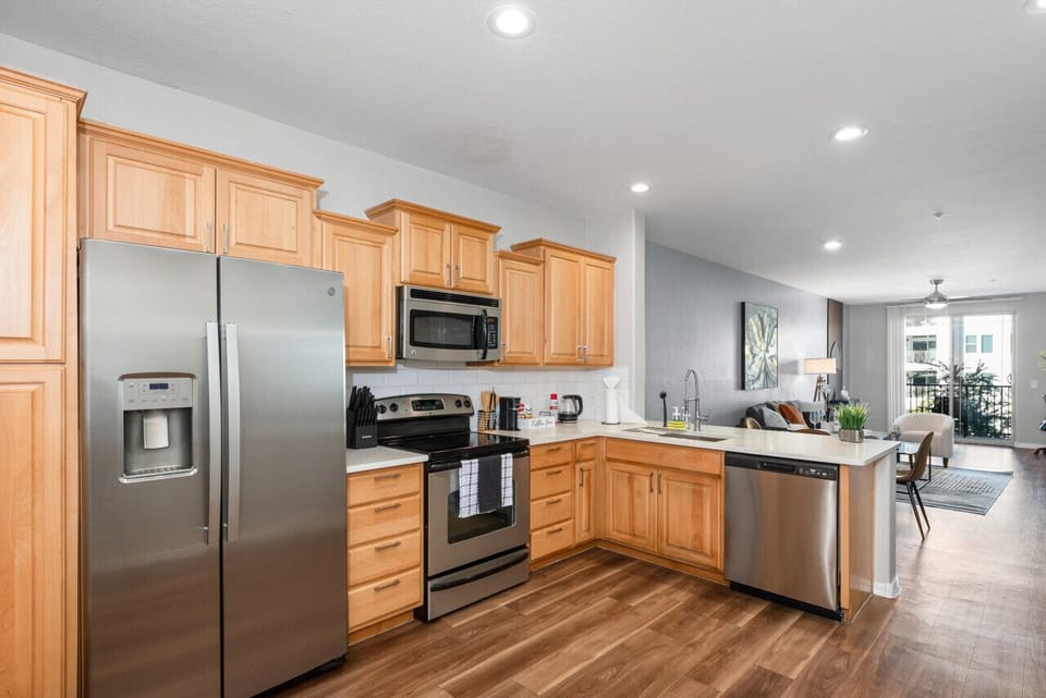 Modern functional kitchen with microwave, fridge, stove and basic cooking ware