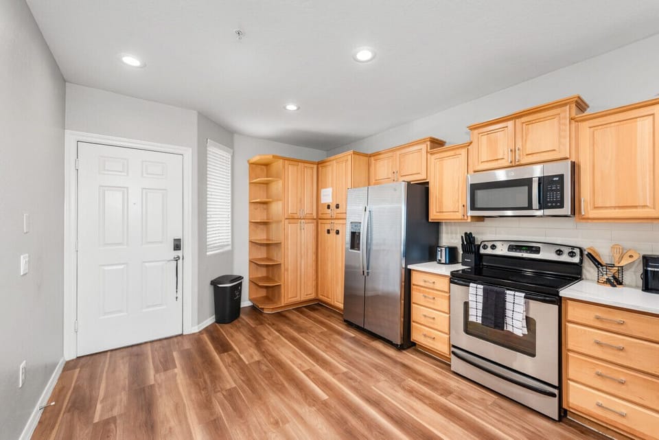 Modern functional kitchen with microwave, fridge, stove and basic cooking ware