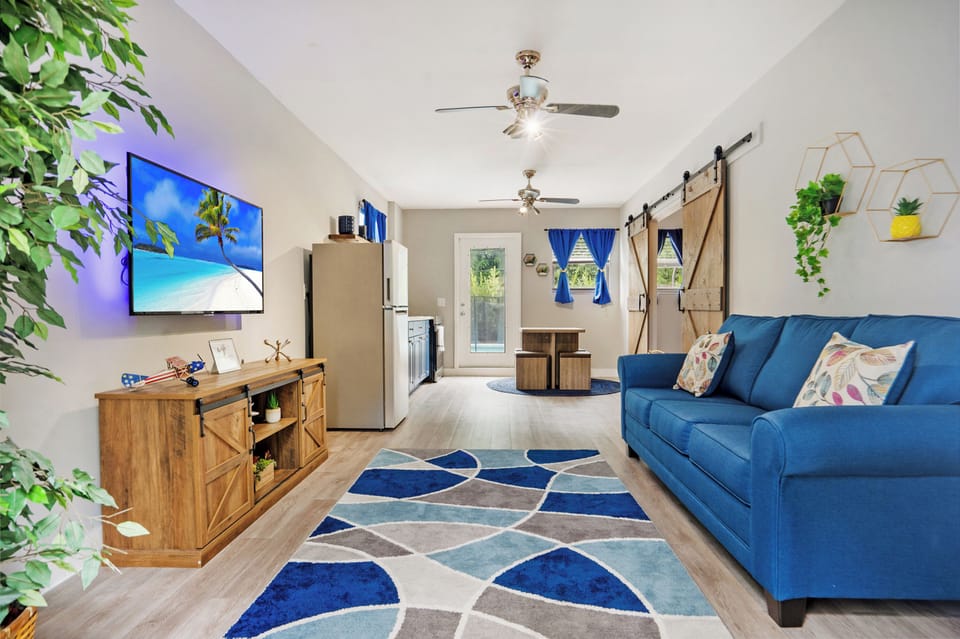 The vibrant living space with a wall mounted Smart TV and plush sofa 