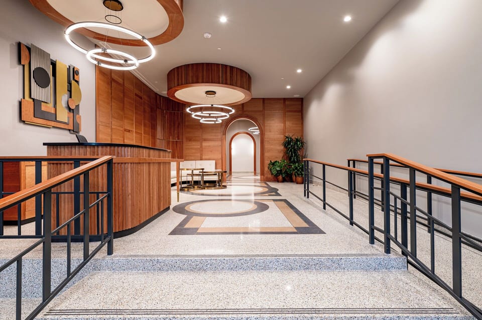 The Mayfair's warm and inviting lobby area showcased with custom art and millwork, leaving a lasting impression.