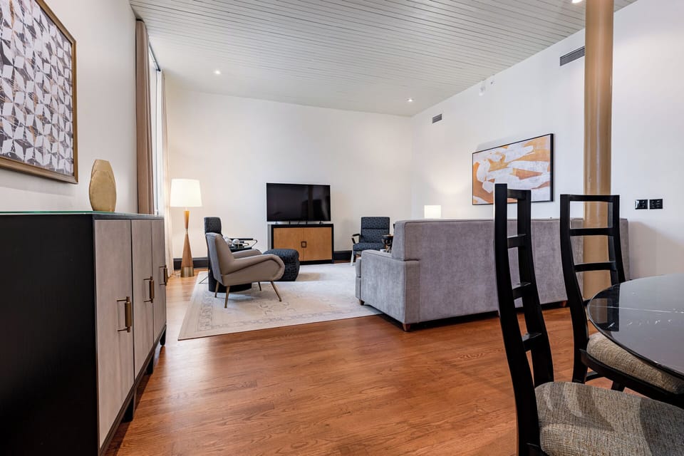 Experience the grandeur of high ceilings and historical architecture, featuring exposed brick and restored columns in this expansive living area.