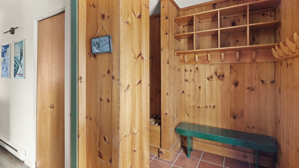 - Mudroom entry with wood paneling and storage cubbies   - Benches and hooks provide ski gear organization   - Practical mountain retreat feature for active stays