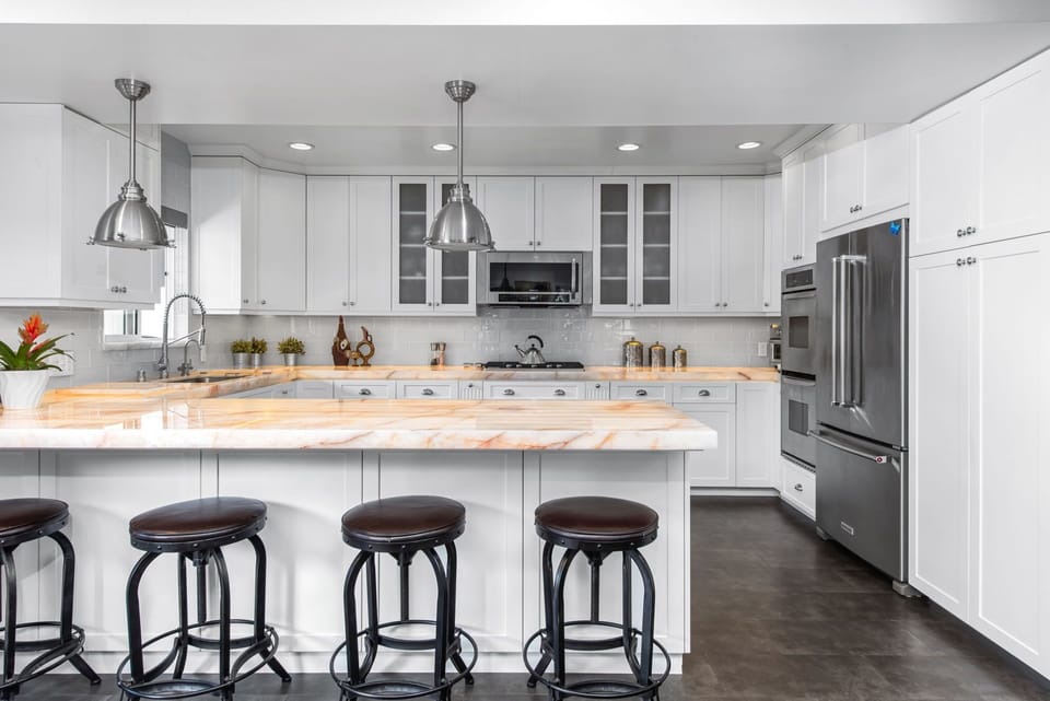 Kitchen with lighted up quartzite counter tops. Peninsula offers 4 bars seats