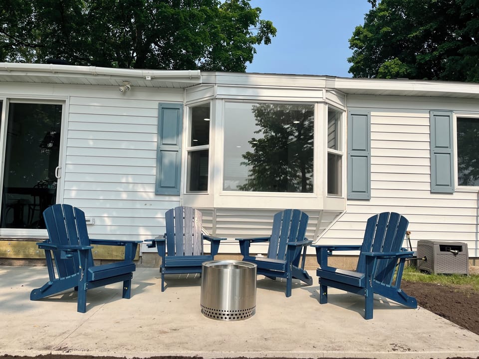 Concrete patio with solo stove fire pit, table + chairs