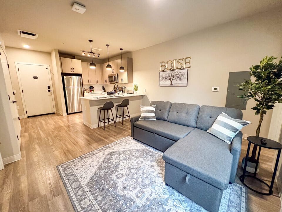 Relax in style in this modern, cozy living space featuring a comfortable sofa, stylish décor, and a fully equipped kitchen—perfect for your stay in downtown Boise!