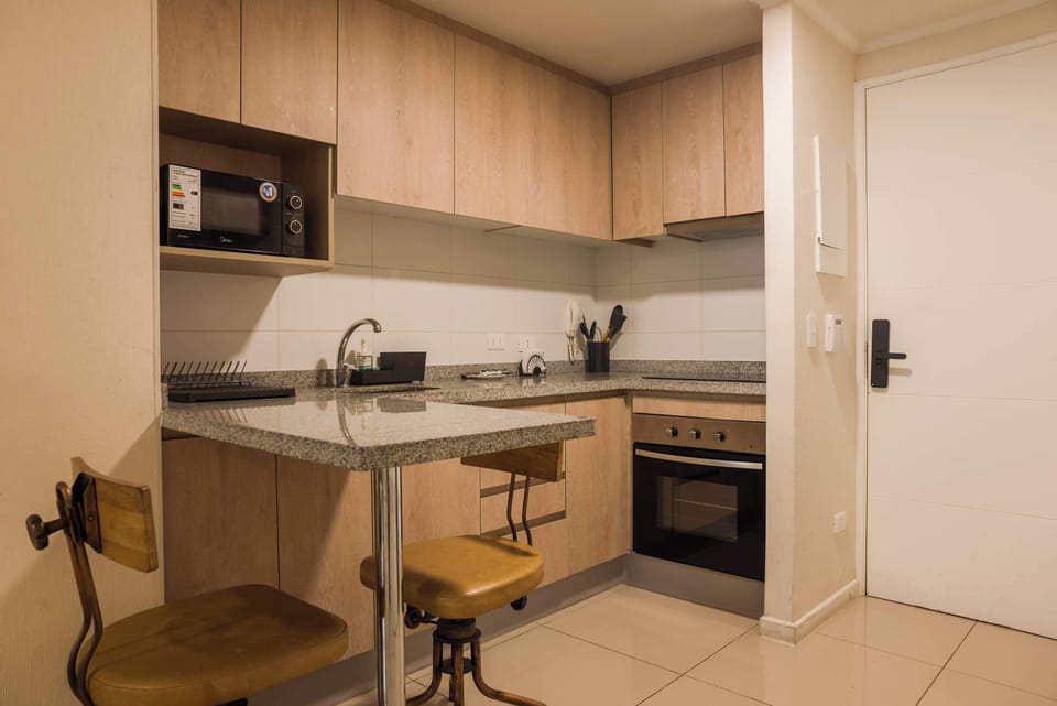 Modern kitchen with sleek granite countertops and cozy seating, perfect for a quick meal or morning coffee.