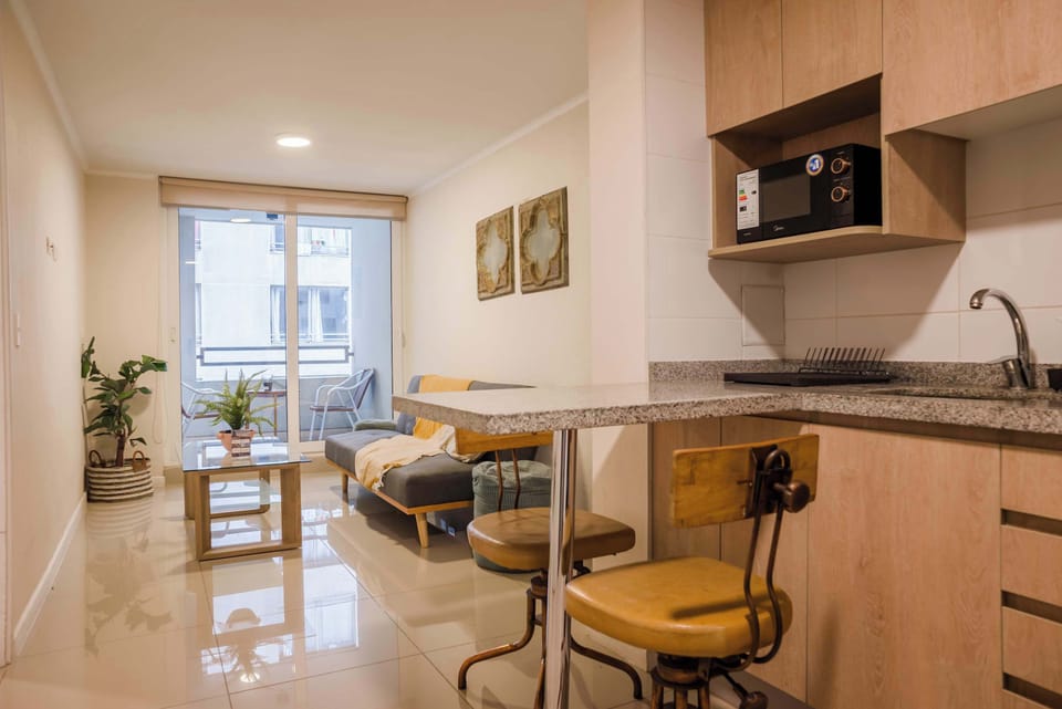 Cozy living area with a kitchenette and balcony access, perfect for relaxing after exploring the city.