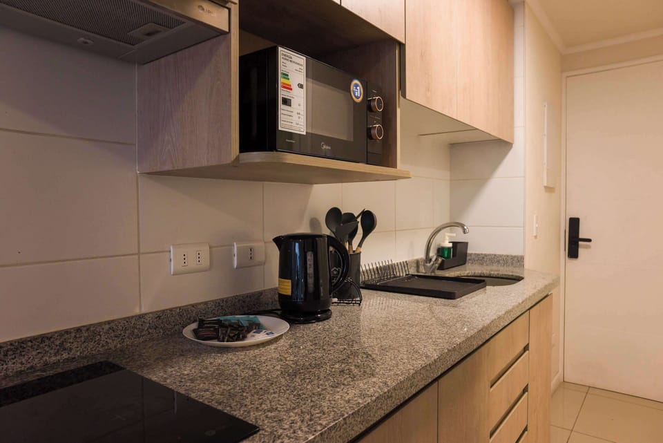 Modern kitchenette with essential appliances and sleek design, perfect for a cozy stay in the heart of the city.