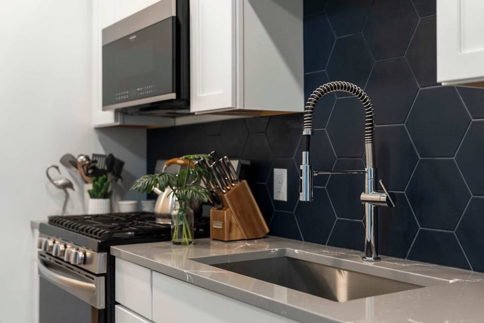 The sleek, open kitchen offers ample space & every home comfort