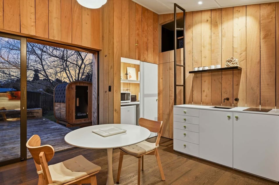 Kitchen and dining at dusk, looking out to the sauna