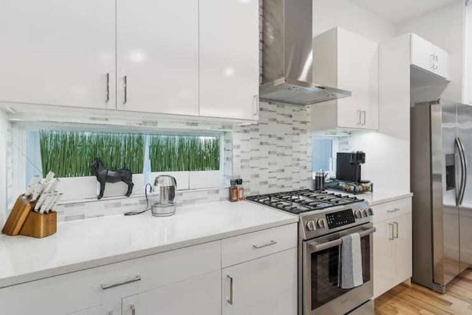 The all-white palette and stainless steel accents create a bright and airy feel
