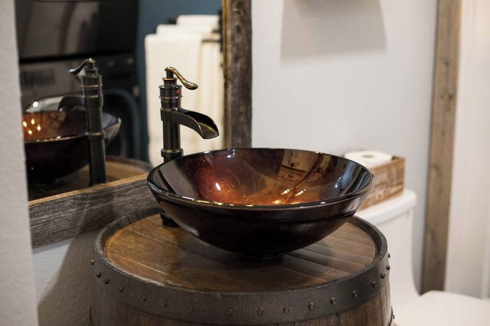 Custom barrel vanity with sink bowl and a spicket faucet. Custom framed mirror. 