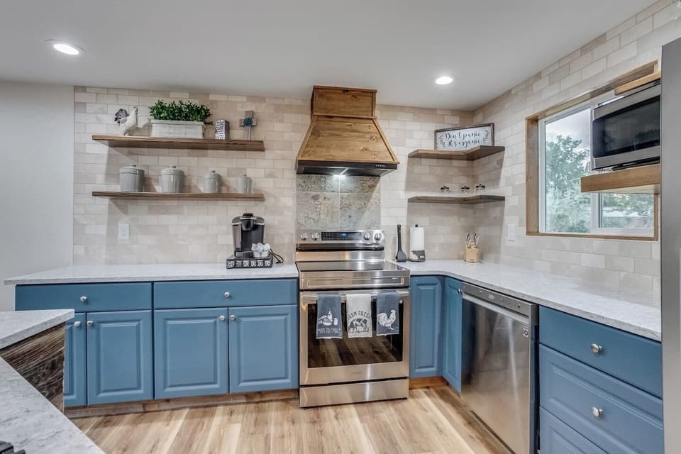 Custom-built range hood, open shelves, and kitchen island. Provided coffee, tea, and hot cocoa Keurig pods. Oven, dishwasher, microwave, full-sized refrigerator, Keurig, sink, cooking utensils,  pots & pans, baking sheet, and more!