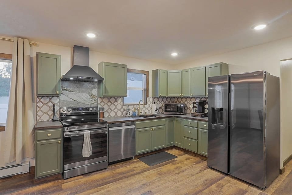 Padded standing mat - Electric range stove  - Dishwasher  - Full sized fridge/freezer  - Keurig coffee machine  - Toaster  - Microwave  - Fully stocked, all cookware and dishware  - Cooking necessities (salt, pepper)  - Pull out trash bin