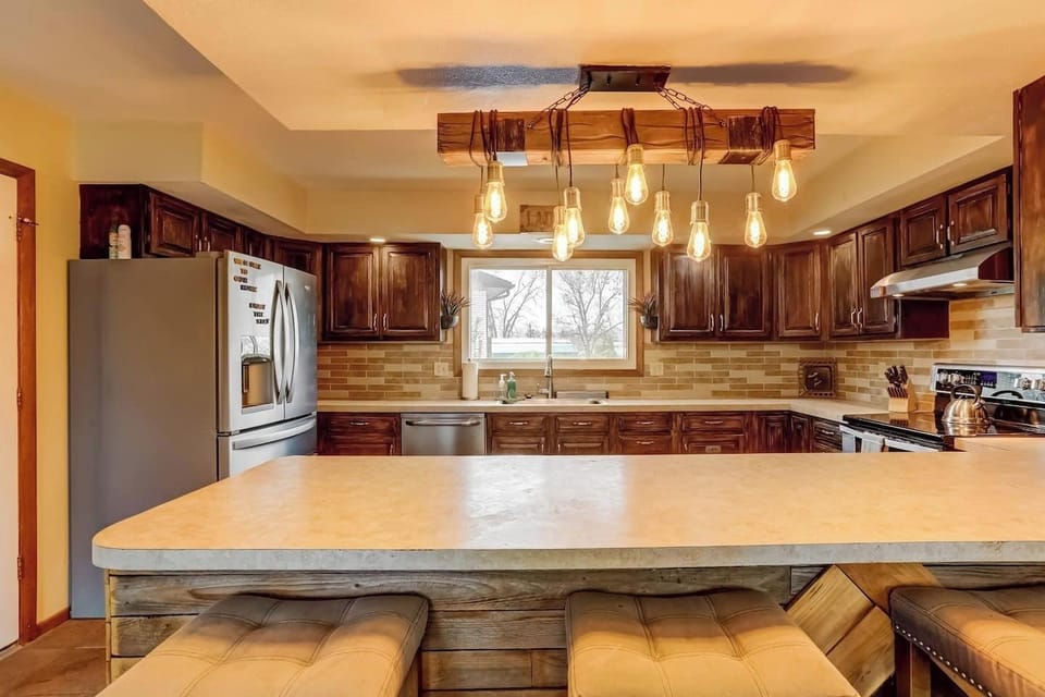 Rustic charm meets modern comfort! 🌟 Cook, chat, or sip morning coffee at this inviting kitchen island under warm, glowing lights. 🍽️☕#HomeAwayFromHome