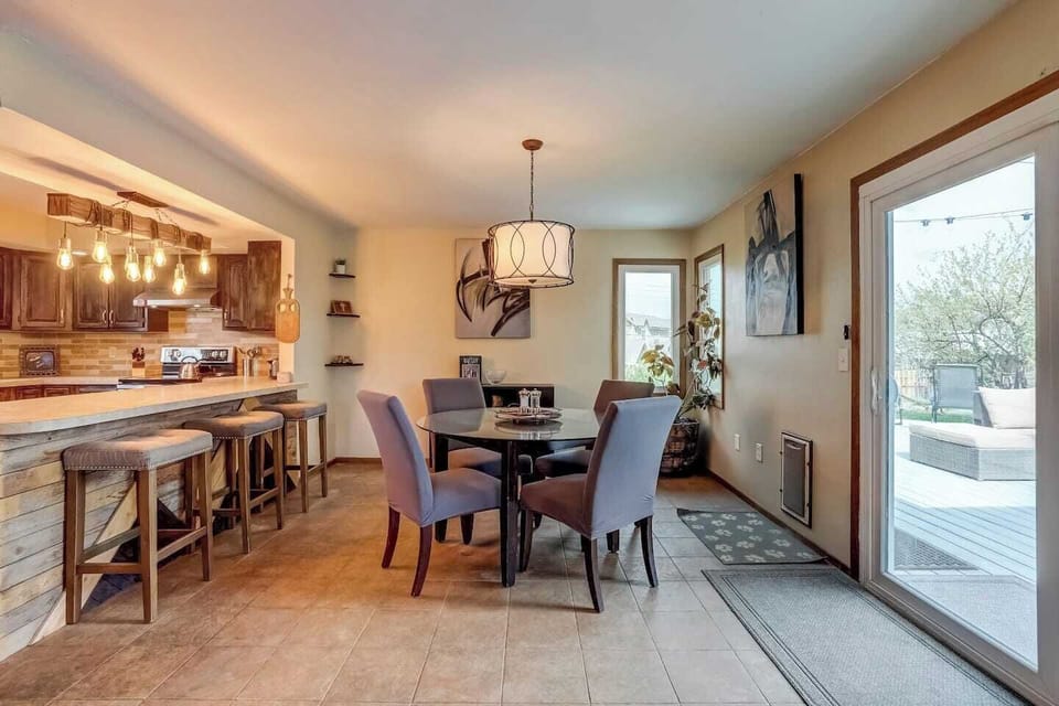 Dining room and kitchen with glass sliding door into the backyard. Seating for 4 people at the dining room table and seats 3 people are the kitchen island