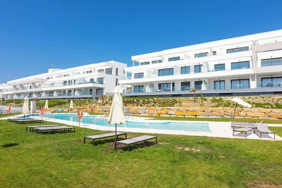 Outdoor communal swimming pool offering panoramic sea views. Equipped with loungers and inside pool 