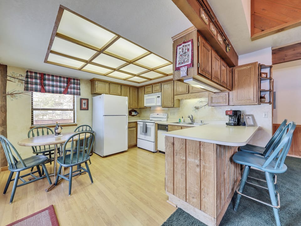 View of the fully equipped kitchen and dining area, perfect for preparing meals and enjoying a cozy night in after a day on the slopes