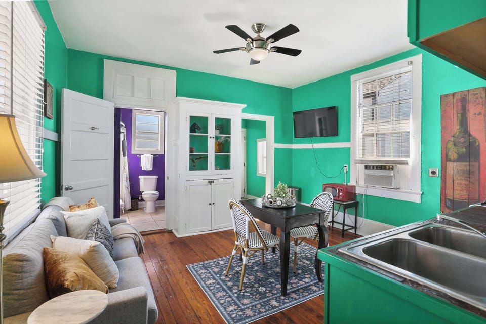 Eat-in kitchen/ Living area featuring a fridge/freezer, full-sized stove, oven, microwave, sink, dining table, sofa, and smart TV