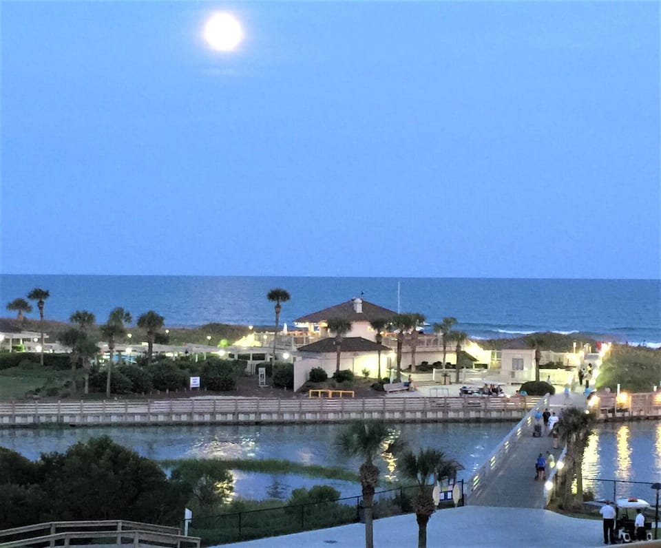 Evening view of the grill, bar & outdoor pool