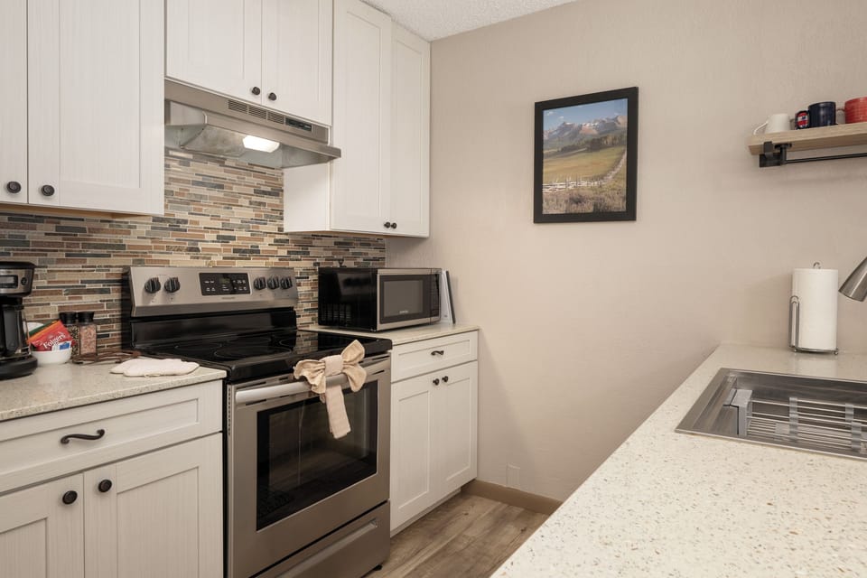 Your fully equipped kitchen awaits with modern appliances, granite counters, and charming tile backsplash—perfect for preparing memorable meals during your stay.