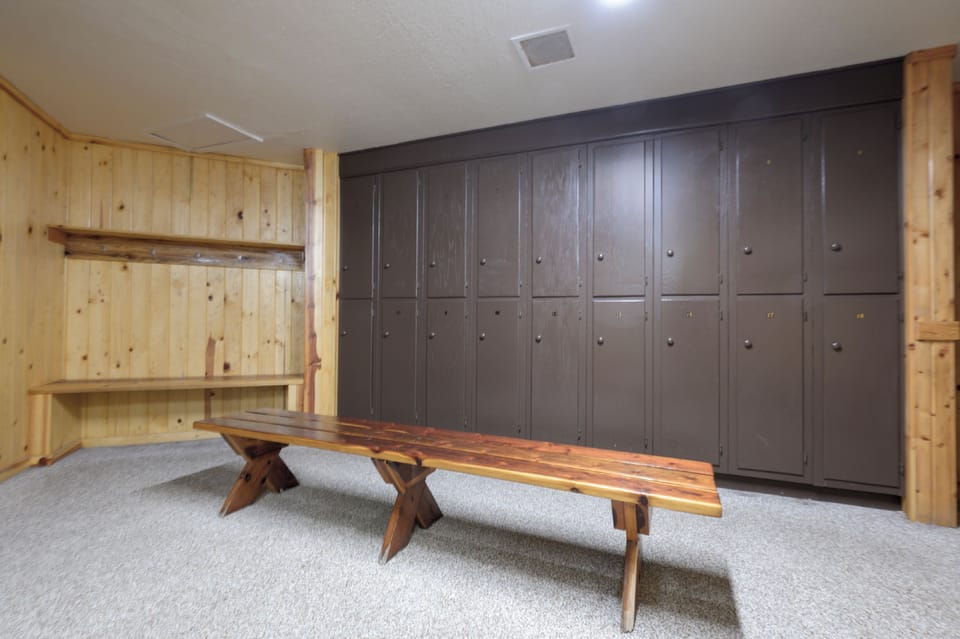 Store your gear in spacious lockers and change comfortably on wooden benches in this well-organized changing room.