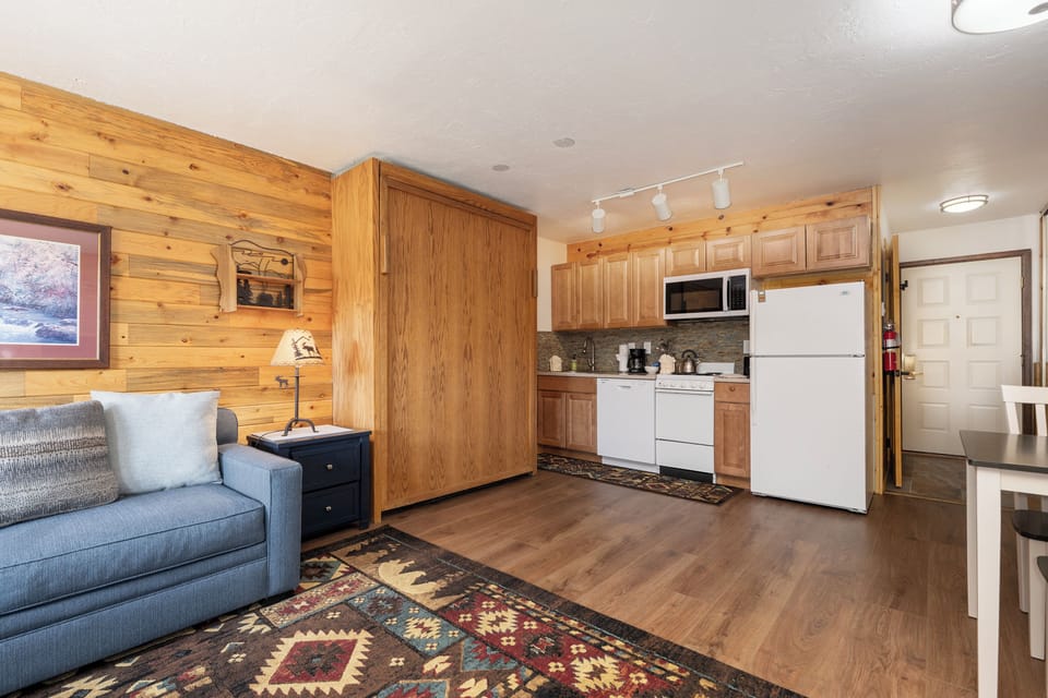 Cozy cabin-style space where rustic wood meets modern comfort, featuring your fully equipped kitchen and relaxing living area.