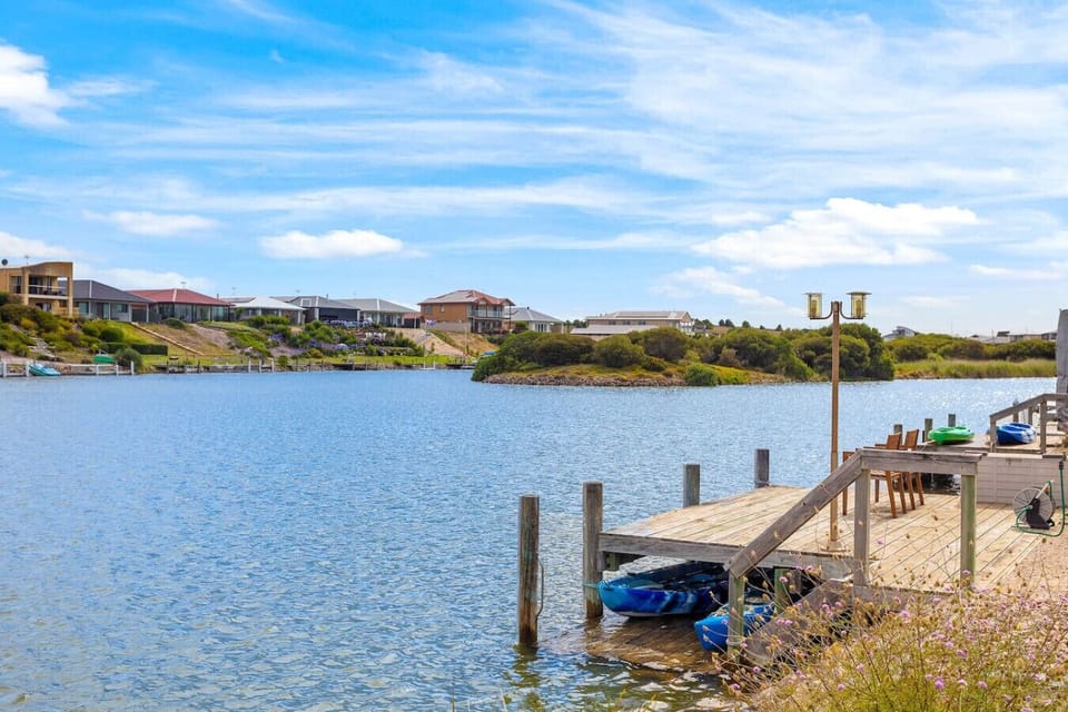 The dock has some kayaks and chairs, suggesting a recreational area by the water.