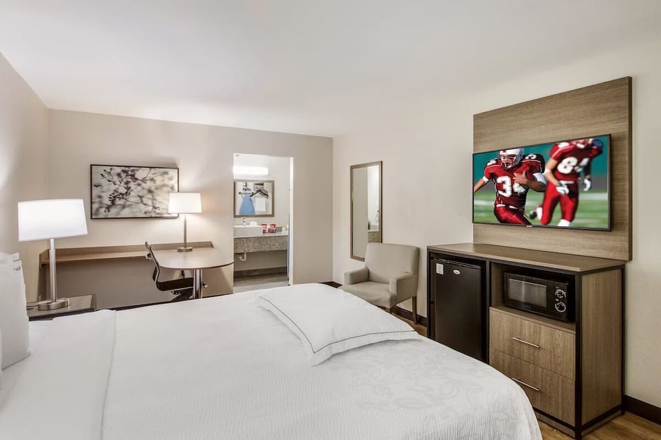 Recharge in a serene king room with fridge and workspace.