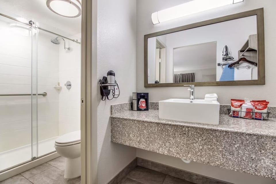 Refresh effortlessly with sleek vanity, bright mirror, and shower.