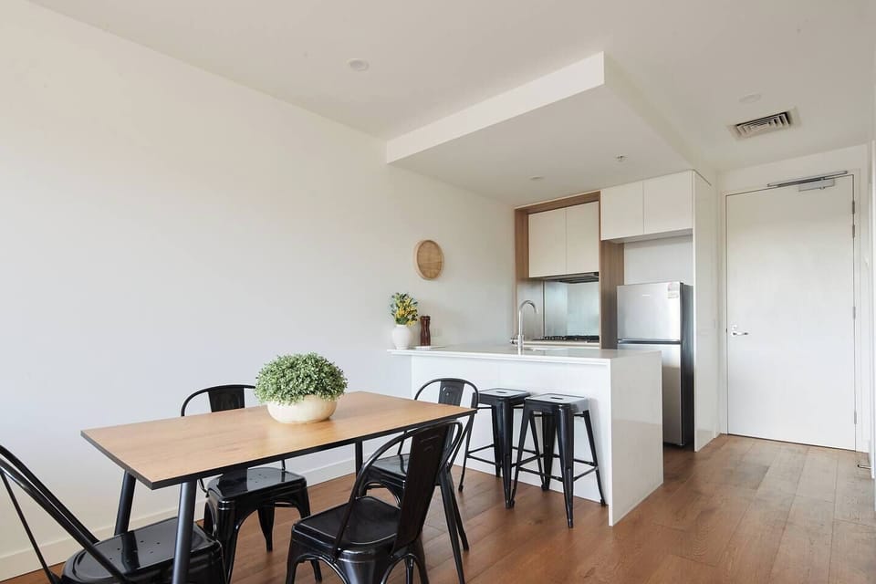 The light and airy kitchen and dining area includes a four-seater table and additional seating at the breakfast bar.