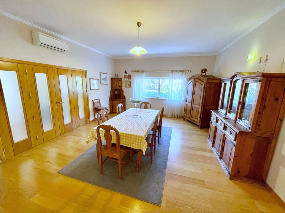 Dining room at Villa Mandarin with wooden table and chairs, warm ambient lighting, and traditional Portuguese decor, ideal for family meals during your Algarve holiday near Carvoeiro