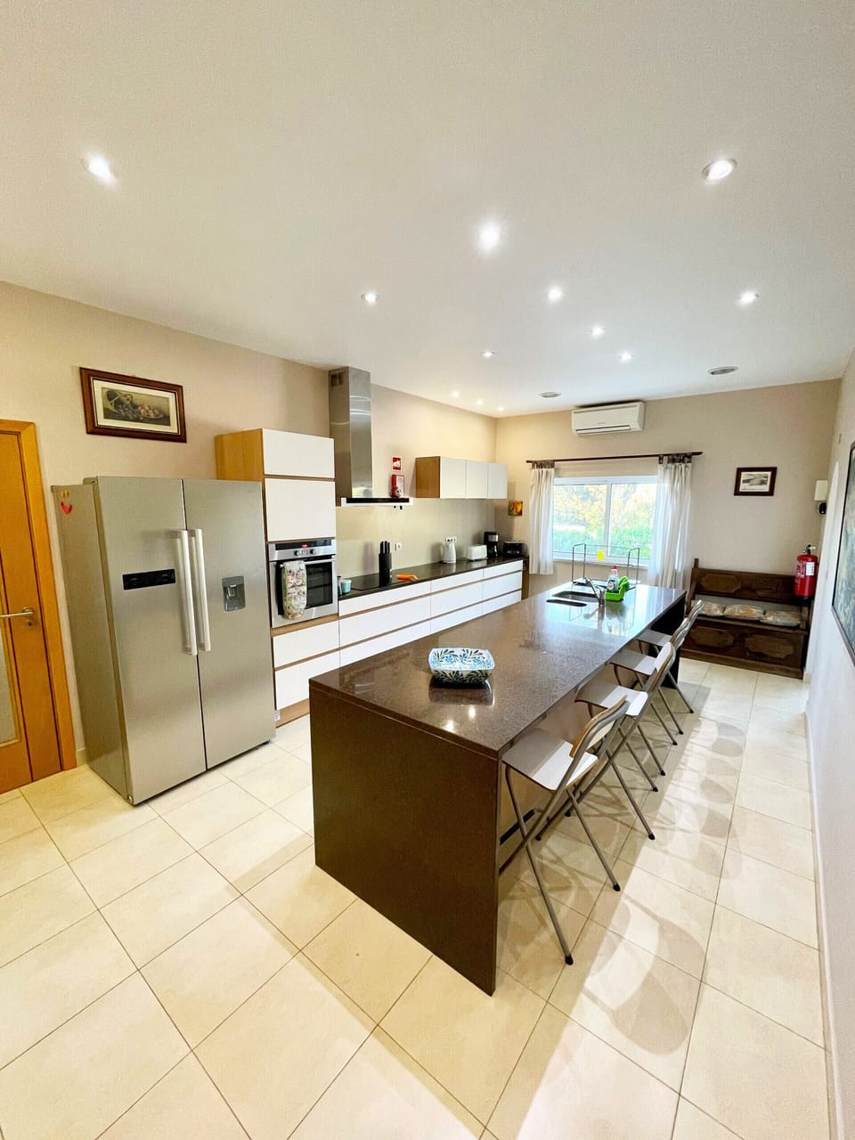 Spacious kitchen at Villa Mandarin with ample counter space, modern built-in appliances, recessed lighting, and tiled flooring in this well-appointed Algarve holiday villa near Carvoeiro